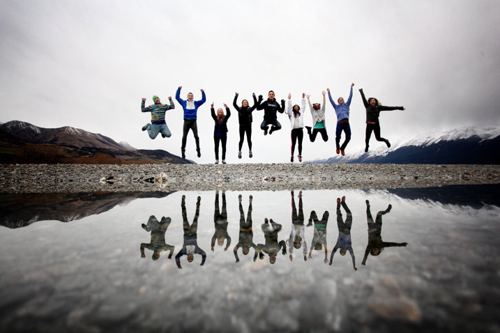 Group of people jumping with mountains in the background