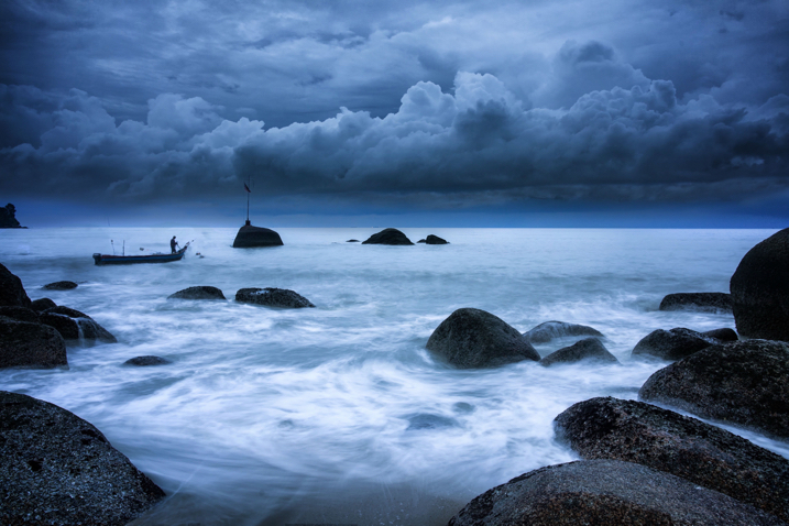 Stormy seascape with boat and rocks