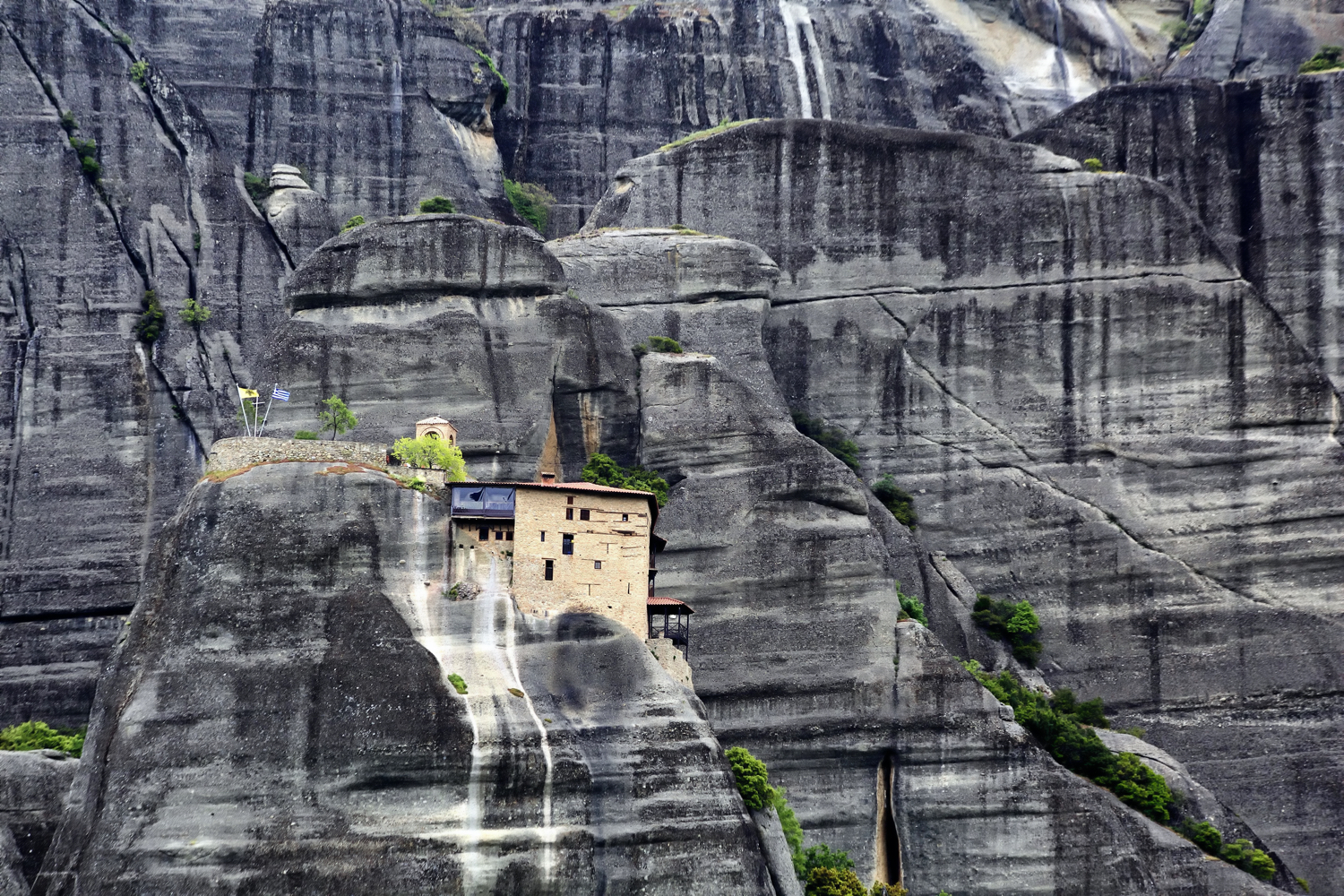 Greek monastery in rock walls of cliff