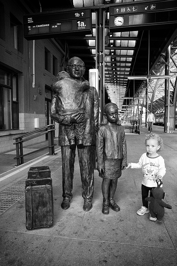 child standing near statues street photo