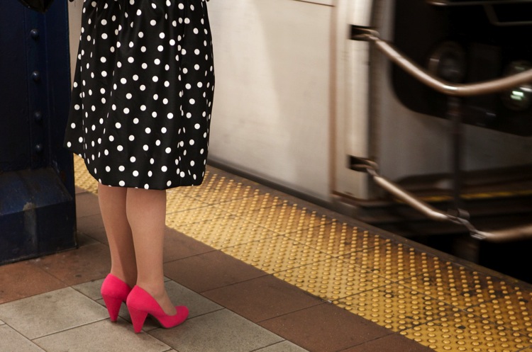 woman with pink shoes on the subway platform