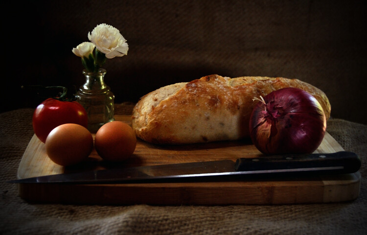 bread, onions, and flowers on a table