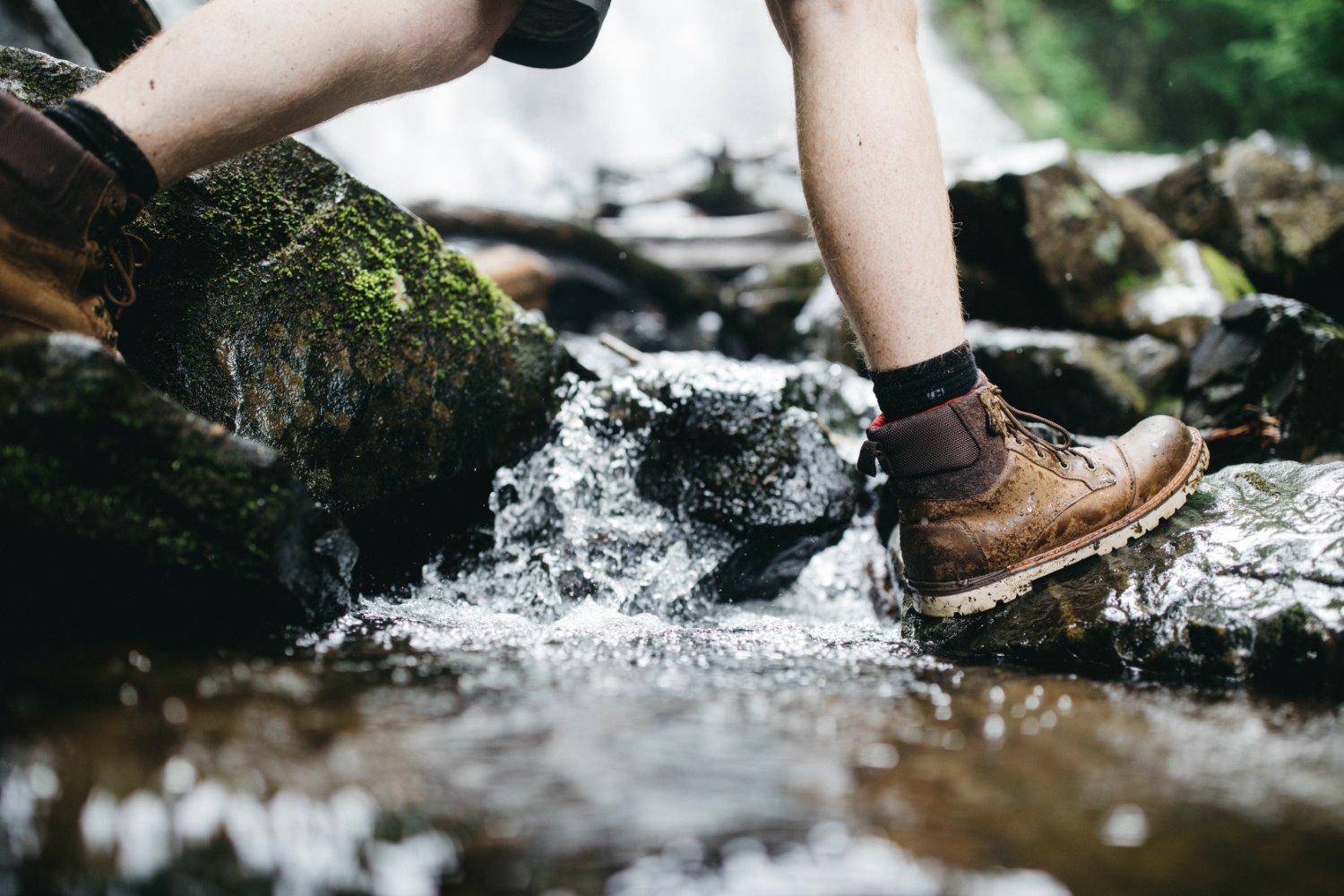 person walking across a stream with hiking boots questions to ask every photographer