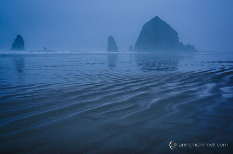 Cannon Beach, Oregon in the fog with sand ripples in the foreground to create depth