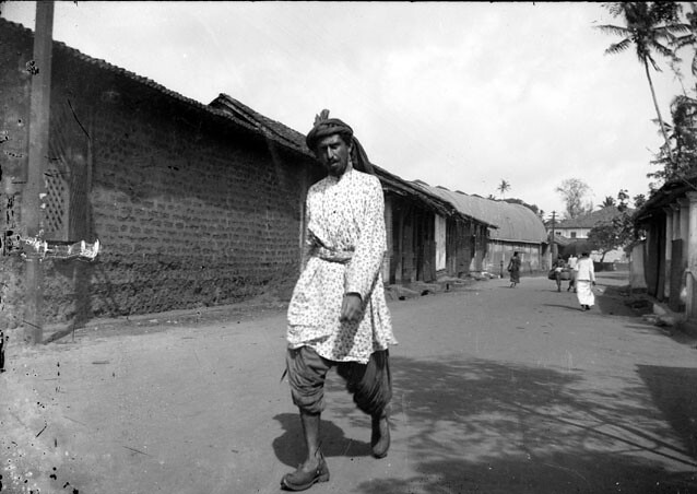 Homme en costume traditionnel et turban marchant dans la rue, Maghreb